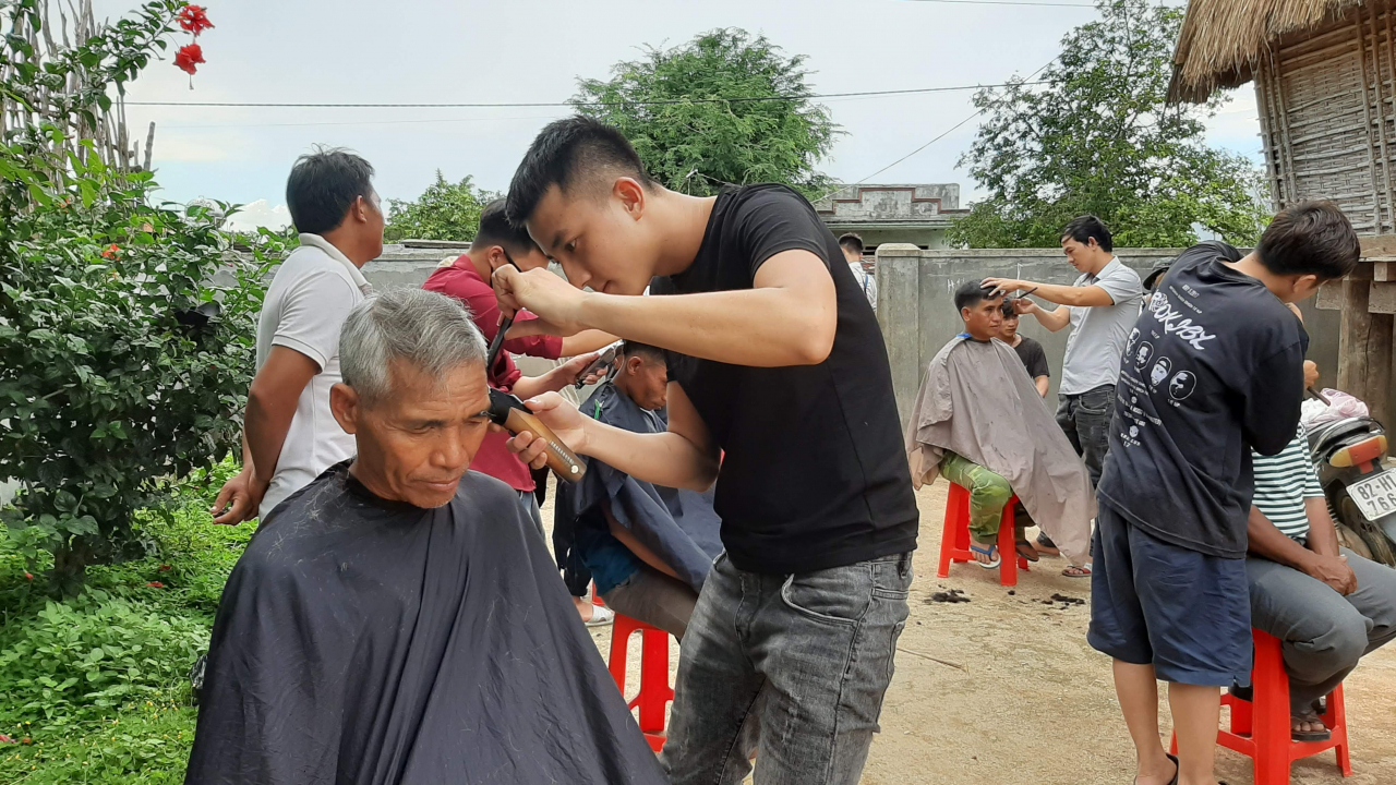 i tình nguyện đang cắt tóc tại phiên chợ......